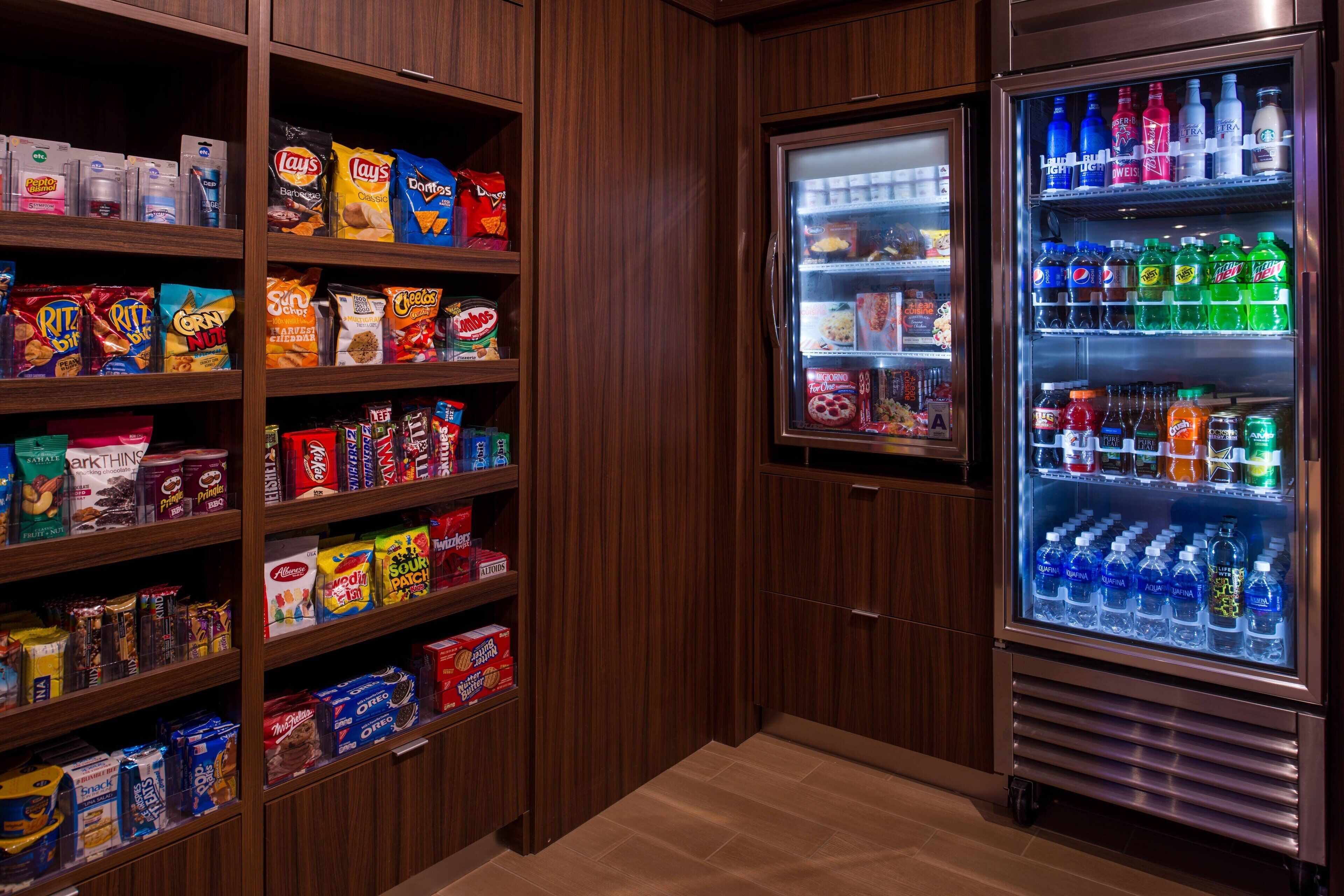 A snack and beverage vending area with various snack brands and bottled drinks.
