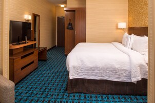A hotel room with a bed, a TV, a desk, and a wardrobe.