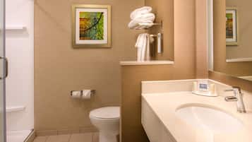 Et moderne badeværelse med toilet, håndvask og bøjlestang til håndklæder.