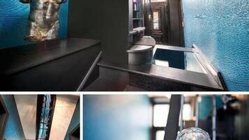 Un couloir d’hôtel moderne avec un mur bleu à texture, une sculpture et un objet décoratif en verre.