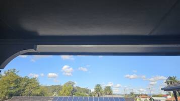 Edificio residencial con techo solar y cielo azul despejado.