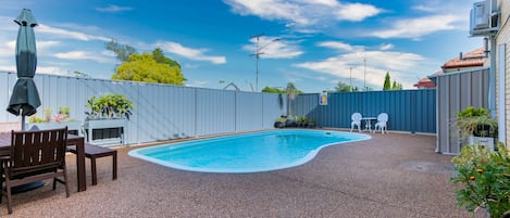 Una piscina al aire libre, sombrillas