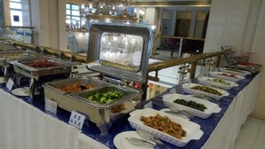 A buffet with various food options, including salads, meats, and other dishes, arranged on a table with a blue tablecloth. - Yangcheng Hotel (Qinhuangdao)