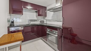 Una cocina moderna con electrodomésticos de acero inoxidable, microondas y horno empotrado.