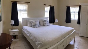 A bedroom with a bed, nightstands, a chair, and a wardrobe.