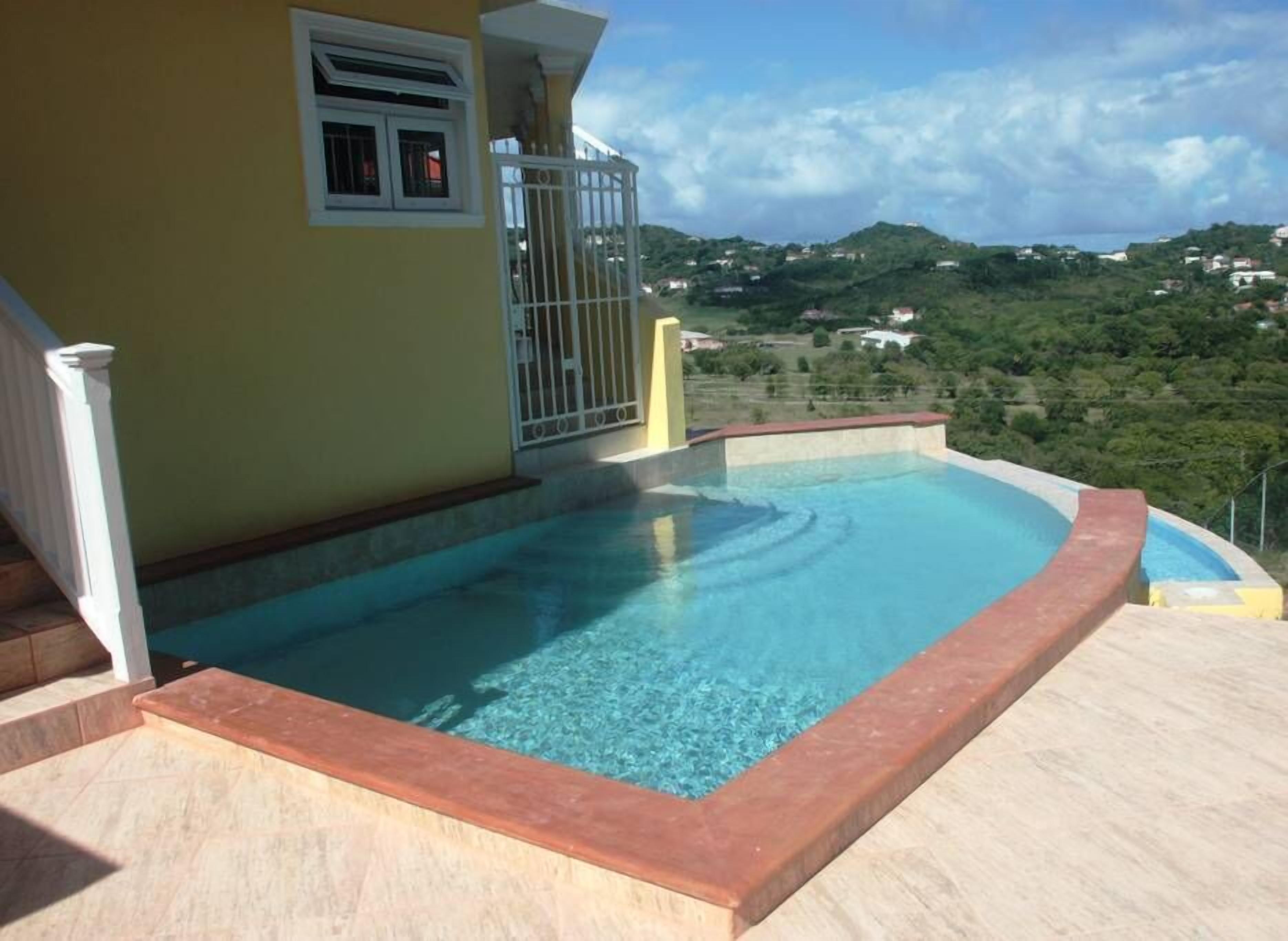A swimming pool with a view of a hilly landscape.