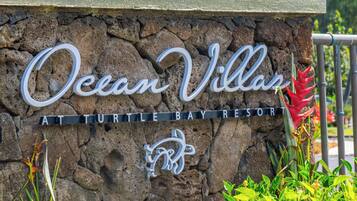 Letrero de Ocean Villa en Turtle Bay Resort, con un fondo de pared de piedra y un logotipo.