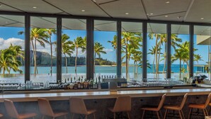 A bar area with a view of the beach and palm trees. - SUMMER REDUCED! Villa 102 KING bed, Stunning Ocean Views at Turtle Bay (Kahuku)