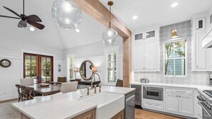 Una cocina con una isla grande, armarios de madera, lavavajillas y estufa.