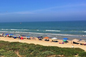 A beach with tents and umbrellas, a sandy shore, and the ocean. - Awesome studio on the beach! ocean views! Sleeps 4, pool, hot tub, BBQ (South Padre Island)
