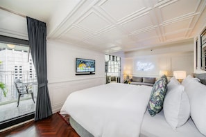 A hotel room with a large bed, a television mounted on the wall, a balcony with a view of the city, and a neon sign. - Akara Hotel Bangkok (Bangkok)