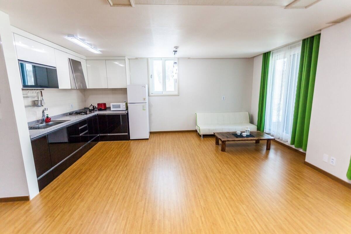 A modern apartment with a kitchen, dining area, and living room.