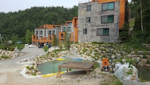 Un edificio moderno con diversi balconi e una facciata in pietra.