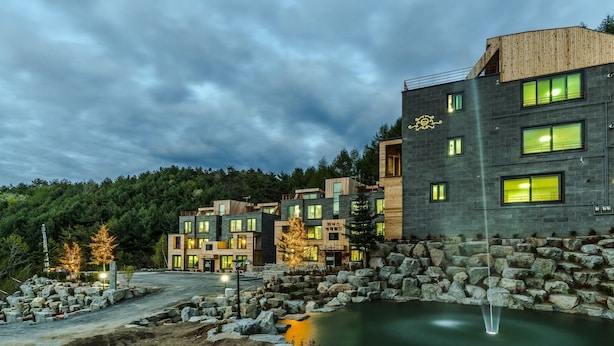 Un edificio moderno con diversi piani, ampie finestre e facciata in pietra.