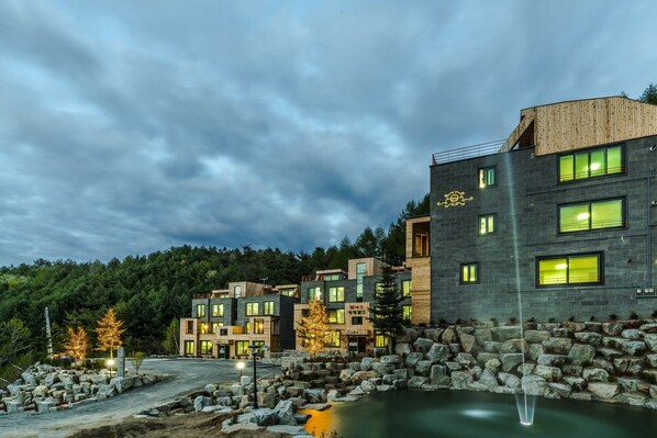 Vista frontal de la propiedad por la tarde o noche