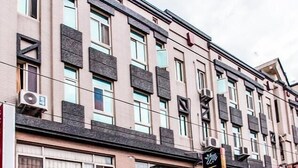 A multi-story building with several ground-floor commercial spaces, including a brightly lit shop with a neon sign. - Hualien 5FM Homestay-Jianlin (Hualien City)