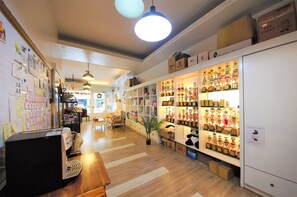 A room with wooden flooring, a desk with a computer, shelves with trophies, and a white cabinet.