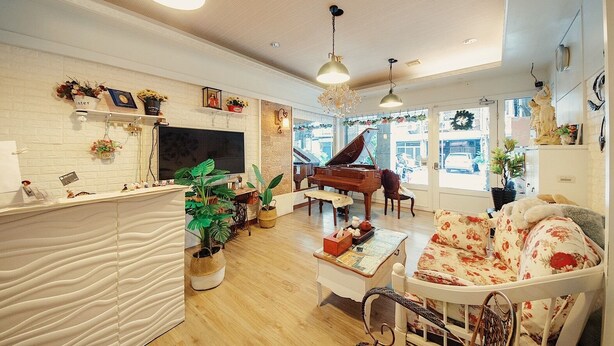 A spacious living room with a piano, a television, and a large window. - Hualien 5FM Homestay-Jianlin (Hualien City)