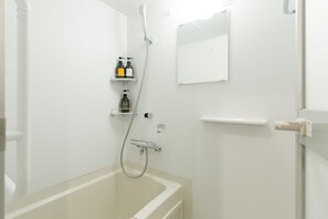 Un baño con bañera, ducha y un estante con artículos de aseo.