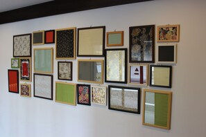 Una pared con varias obras de arte enmarcadas.