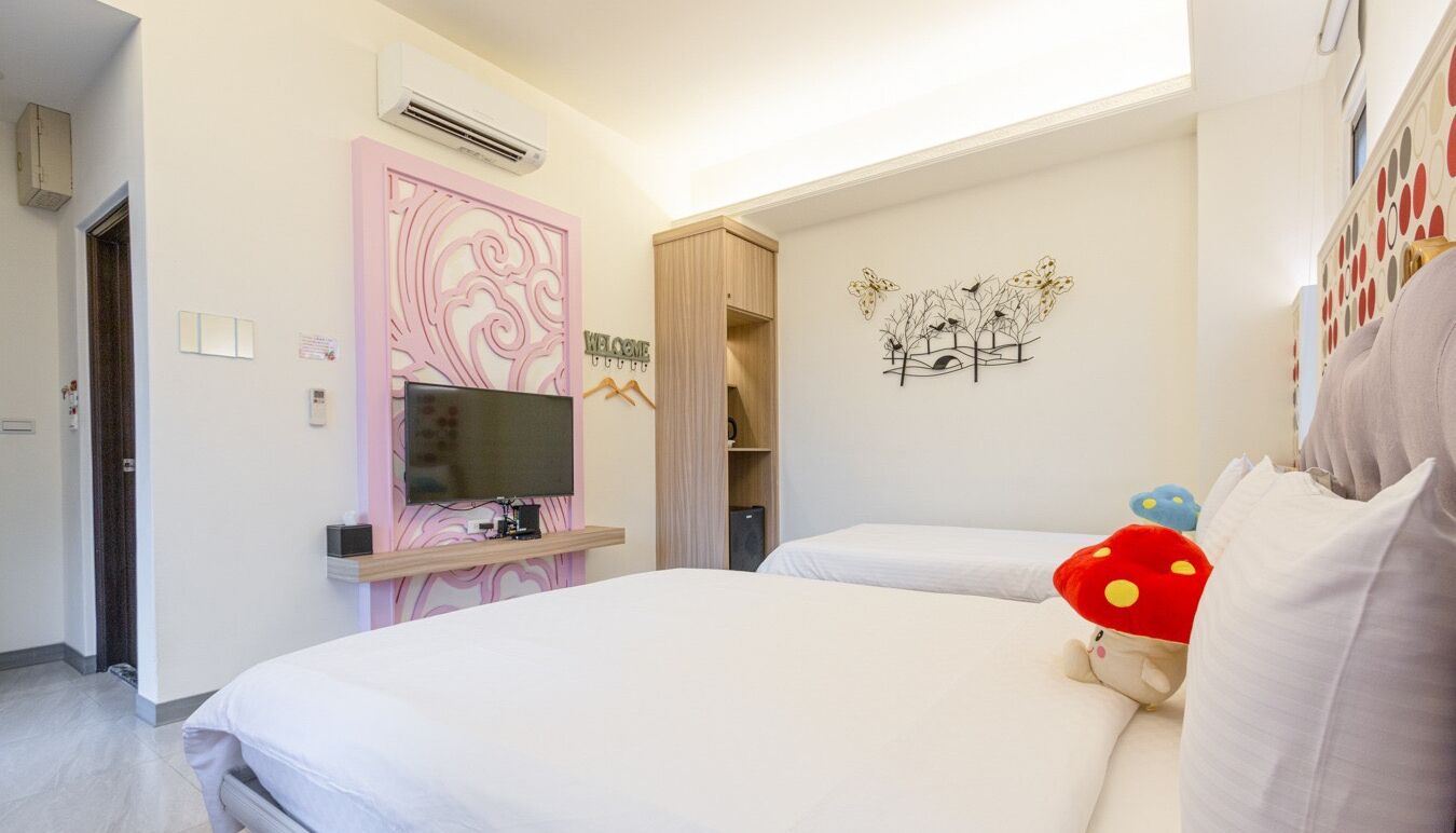 A hotel room with a bed, a TV, a wardrobe, and a wall decoration.