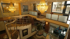 A multi-level hotel lobby with a grand chandelier, a spiral staircase, and a seating area with sofas and a coffee table. - Malabadi Hotel (Diyarbakir)