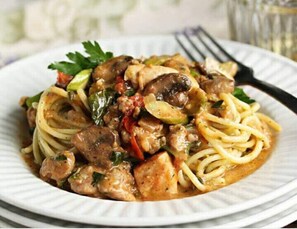 A plate of spaghetti with meatballs and vegetables.