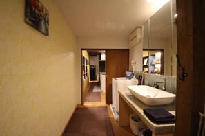 A narrow hallway leading to a bathroom with a sink, mirror, and towel rack. - Nishijin No Sato (Kyoto)