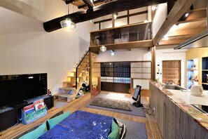 A multi-level living space with a TV, seating area, and kitchen. - Nishijin No Sato (Kyoto)