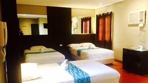 A hotel room with two beds, a bedside table, a mirror, and a telephone.