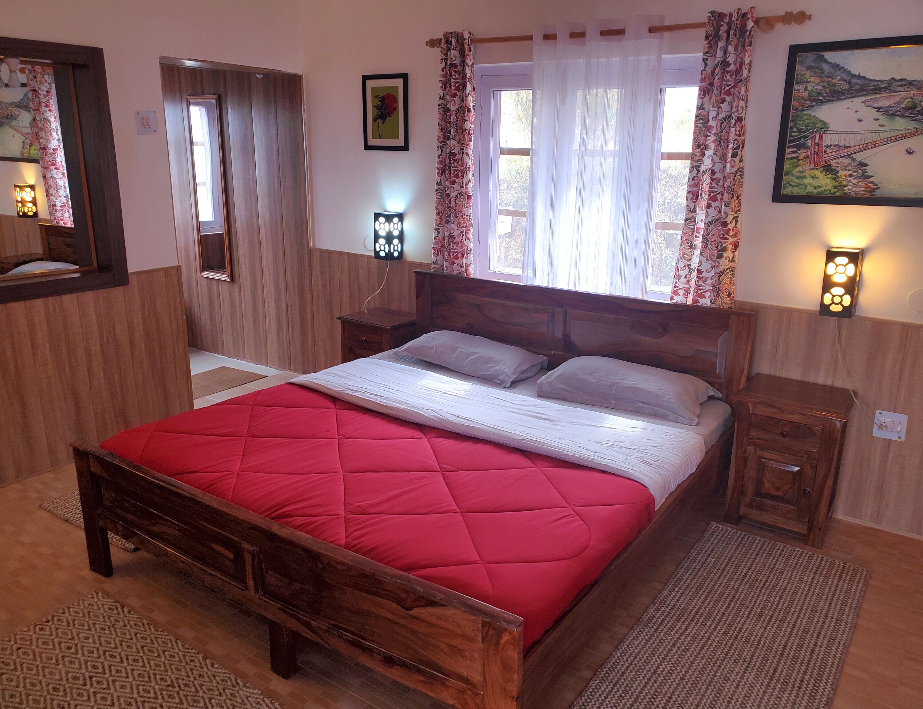 Quarto com cama de madeira, mesa de cabeceira, espelho e janela com cortinas.