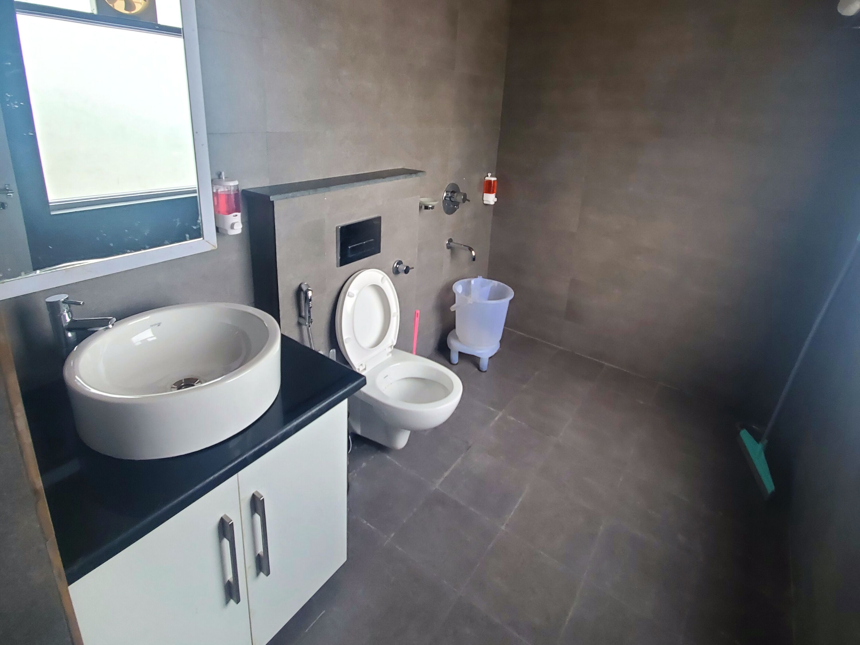 A modern bathroom with a large sink, a toilet, and a bidet.