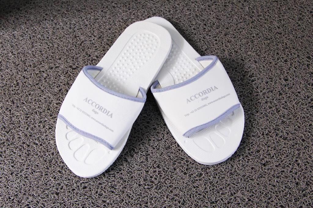 Un par de zapatillas blancas con el nombre de la marca 'ACCORDIA' en la suela.