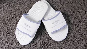 Un par de zapatillas blancas con el nombre de la marca 'ACCORDIA' en la suela.