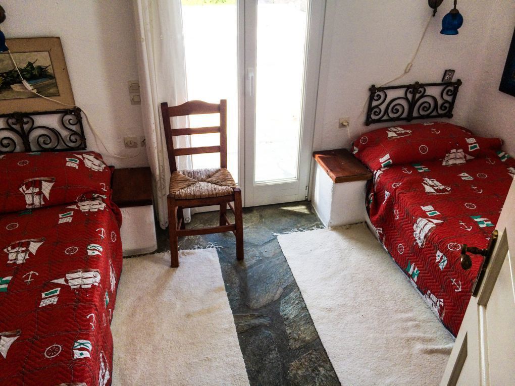 A room with two beds, a chair, and a door.