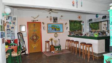 Una habitación acogedora con comedor, bar y una guitarra.