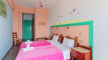 A hotel room with two beds, a wooden nightstand, a chair, and a door leading to another room.