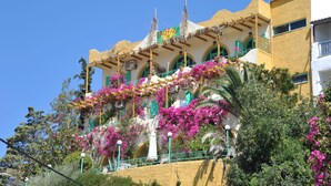 A building with a balcony adorned with pink flowers and a sign that reads "CROFT". - Erofili Rooms (Agios Vasileios)