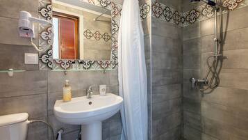 Un bagno con lavandino, specchio, doccia e piastrelle decorative.