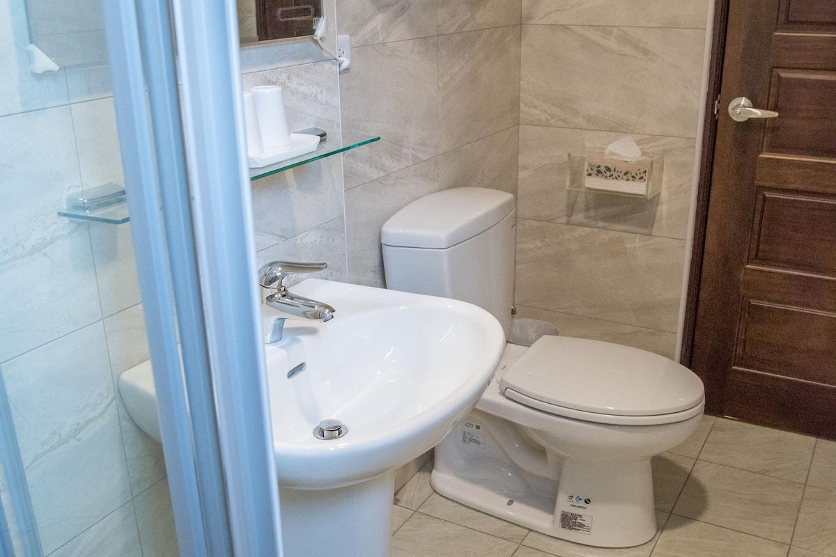 Deluxe-Vierbettzimmer | Badezimmer | Dusche, kostenlose Toilettenartikel, Haartrockner, Hausschuhe