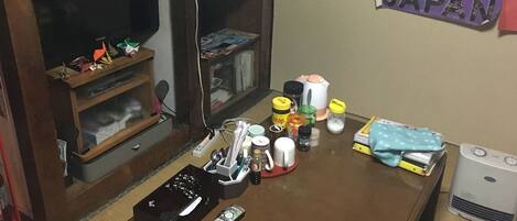 A cluttered room with a television, various papers, and a 'Explore JAPAN' poster on the wall.