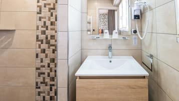 Une salle de bain moderne avec un lavabo blanc, un meuble-lavabo en bois et un porte-serviettes.