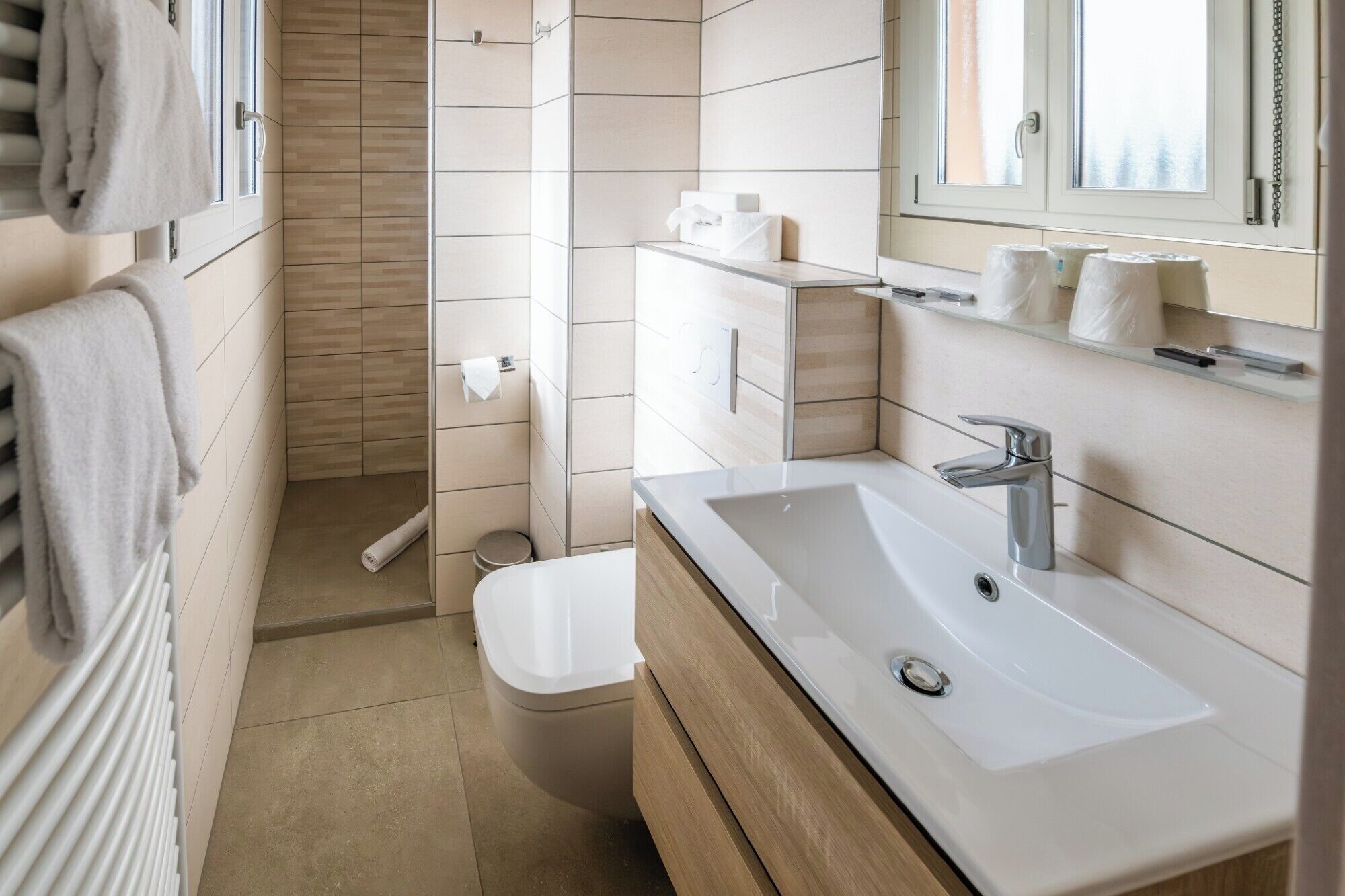 A modern bathroom with a white sink, a mirror, and a toilet.