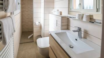 Et stilfuldt badeværelse med en hvid vask, et spejl og et toilet.