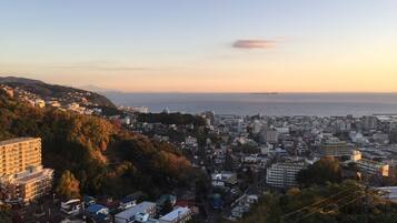 A coastal cityscape with dense urban development, a prominent high-rise building, and a view of the sea.