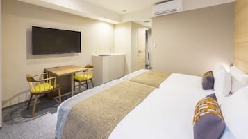 A hotel room with a bed, a desk, a chair, a television, and an air conditioning unit.