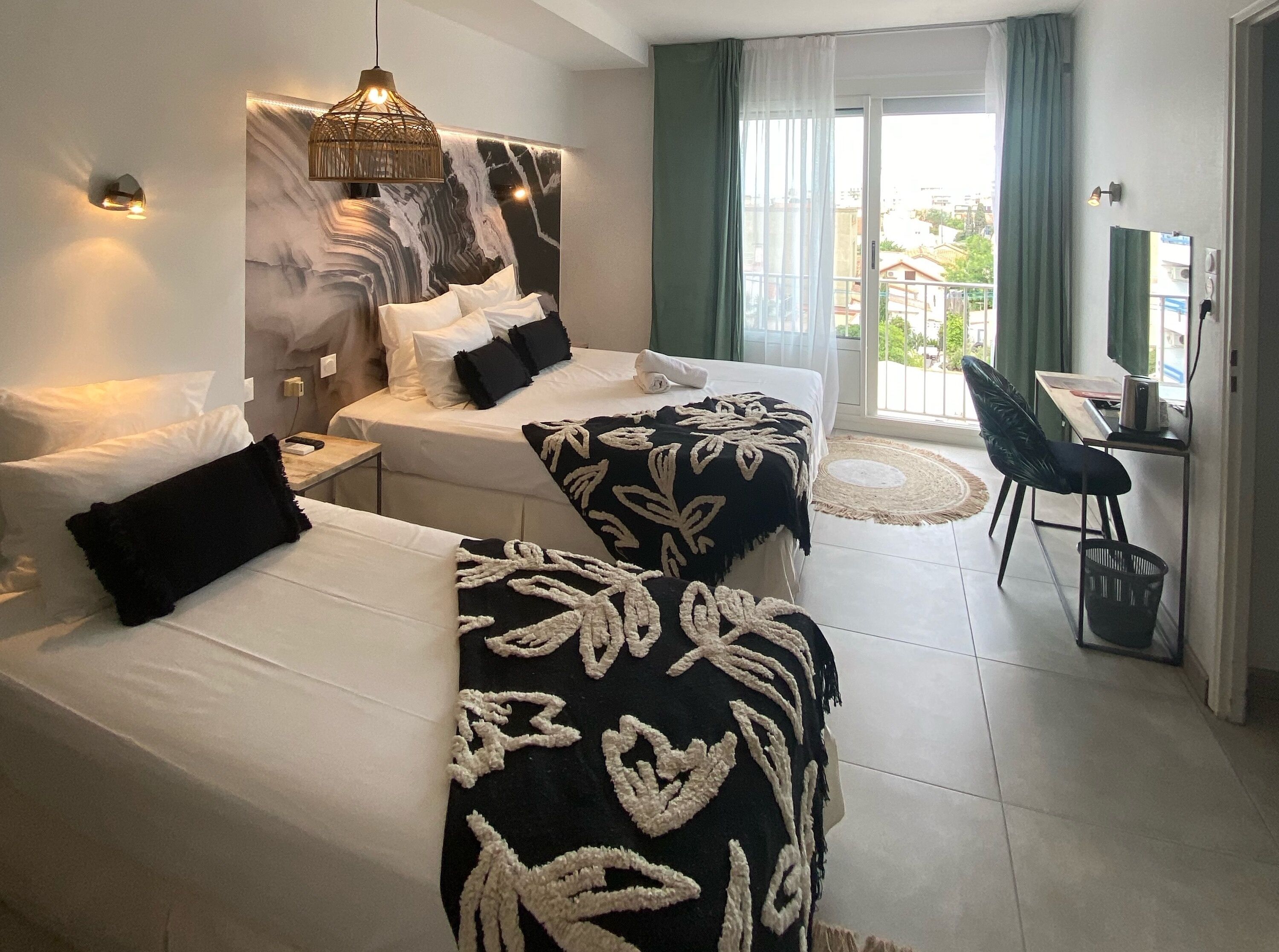 A modern hotel room with two beds, a desk, and a chair.