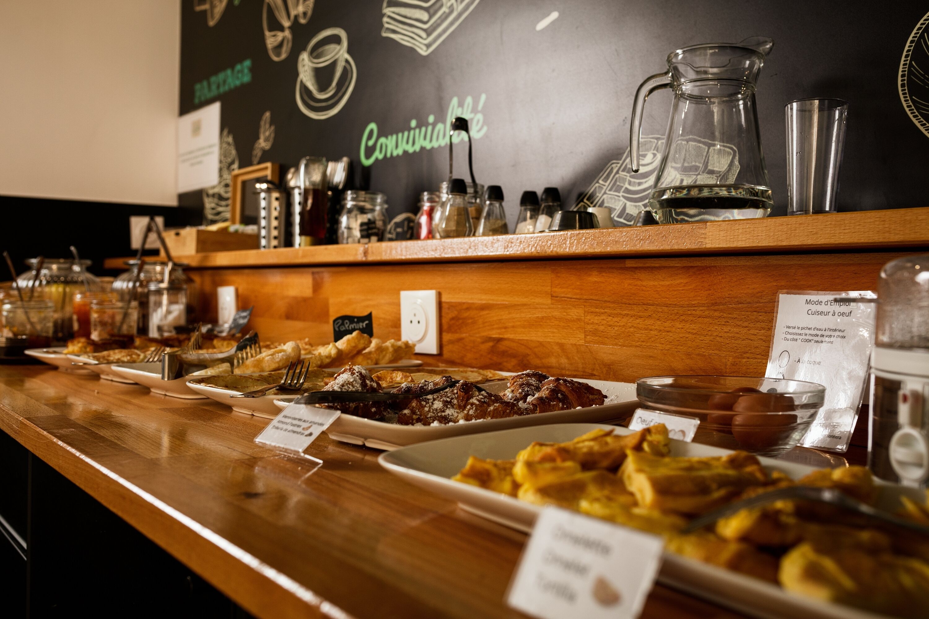 A buffet counter with various food items and condiments.
