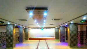 A spacious indoor area with a polished floor, patterned pillars, and recessed lighting. - Hotels Diamond Glory - Mandarmani (Kanthi)