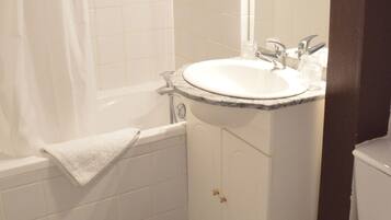 Un baño con bañera, lavabo e inodoro.